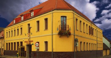 żółty budynek z czerwonym dachem, widziany od frontu