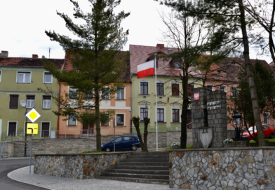 Obchody Narodowego Święta Niepodległości w Zawidowie Pomnik przy placu zwycięstwa, drzewa maszt flagowy, kamienice