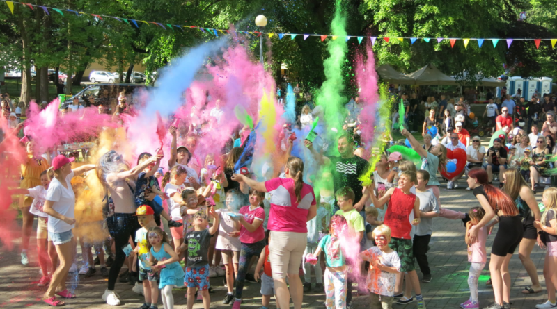 grupa dzieci bawiących się kolorowym pudrem Kolory Holi