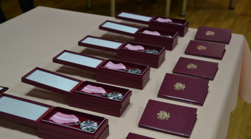 sześć bordowych pudełeczek zawierających medale od prezydenta RP. Medale w kolorze jasnoróżowym
