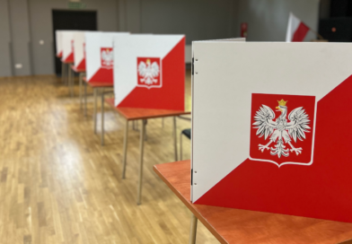 miejsca do głosowania w lokalu wyborczym, stoliki na których poustawiane są tekturowe biało-czerwone zasłony, z godłem Polski.