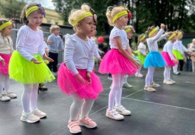 dziewczynki tańczące na scenie różowych i żółtych spódniczkach