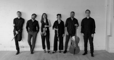 czarno-białe zdjęcie a na nim 6 młodych muzyków, stojących pod ścianą, jeden z mężczyzn z kontrabasem.