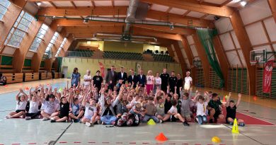 sala sportowa a w niej ponad 70. dzieci w wieku 7-9 lat ustawionych do zdjęcia grupowego.