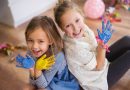 Kreatywne zajęcia plastyczne dla dzieci w Zawidowie dwie dziewczynki pozujące do zdjęcia z pomalowanymi dłońmi.