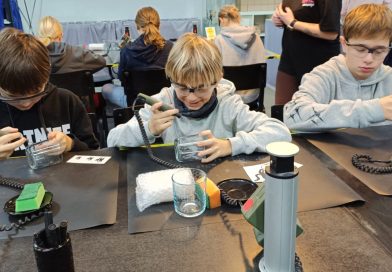 Poznawali, jak powstaje kryształ — wyjazd uczniów do Piechowic Trzech chłopców siedzących przy stołach rzemieślniczych, tworzących szklane gadżety.