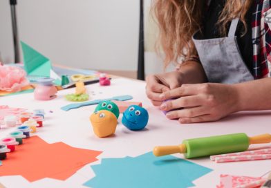 Ferie zimowe w Ośrodku Kultury w Zawidowie Dziecko siedzące przy stole i bawiące się plasteliną.