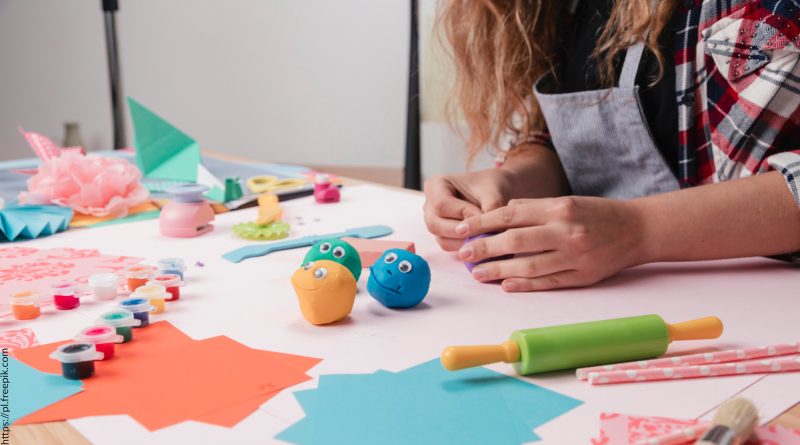 Ferie zimowe w Ośrodku Kultury w Zawidowie Dziecko siedzące przy stole i bawiące się plasteliną.