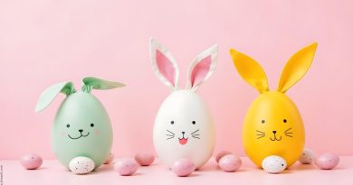 Różowe tło, a na nim zielone, białe oraz żółte jajka udekorowane jak wielkanocne zajączki.