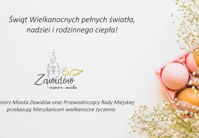 Kolorowe jaka oraz dekoracja świąteczna z drobnych kwiatuszków (gipsówka), napis: Życzenia wielkanocne od Burmistrza Miasta Zawidów i Przewodniczącego RM oraz logo miasta z wieżą kościoła katolickiego.